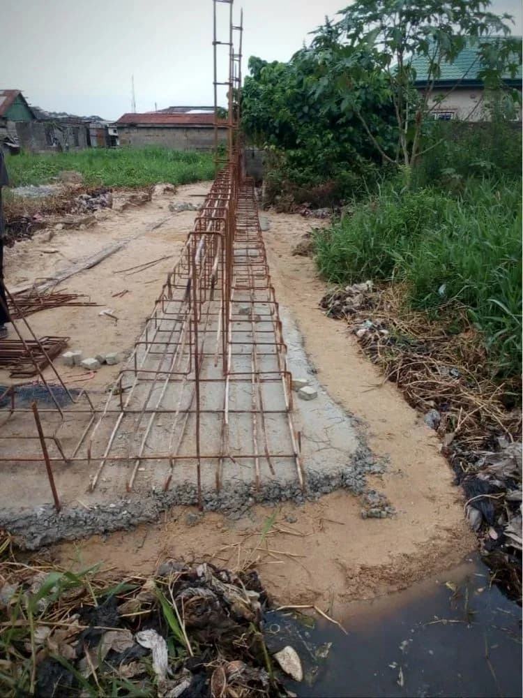 Iron rods bent and tied for a strip foundation on site, with starter bars for the columns