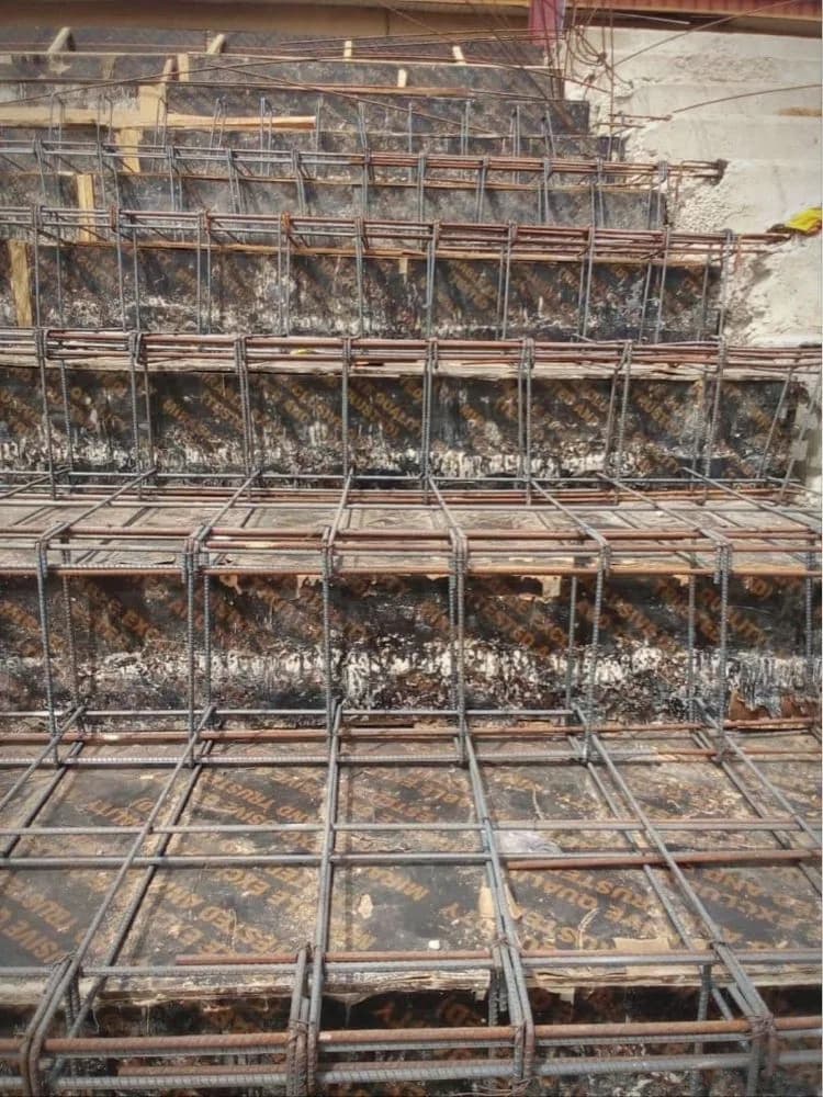Iron rods tied over formwork for a concrete staircase on site