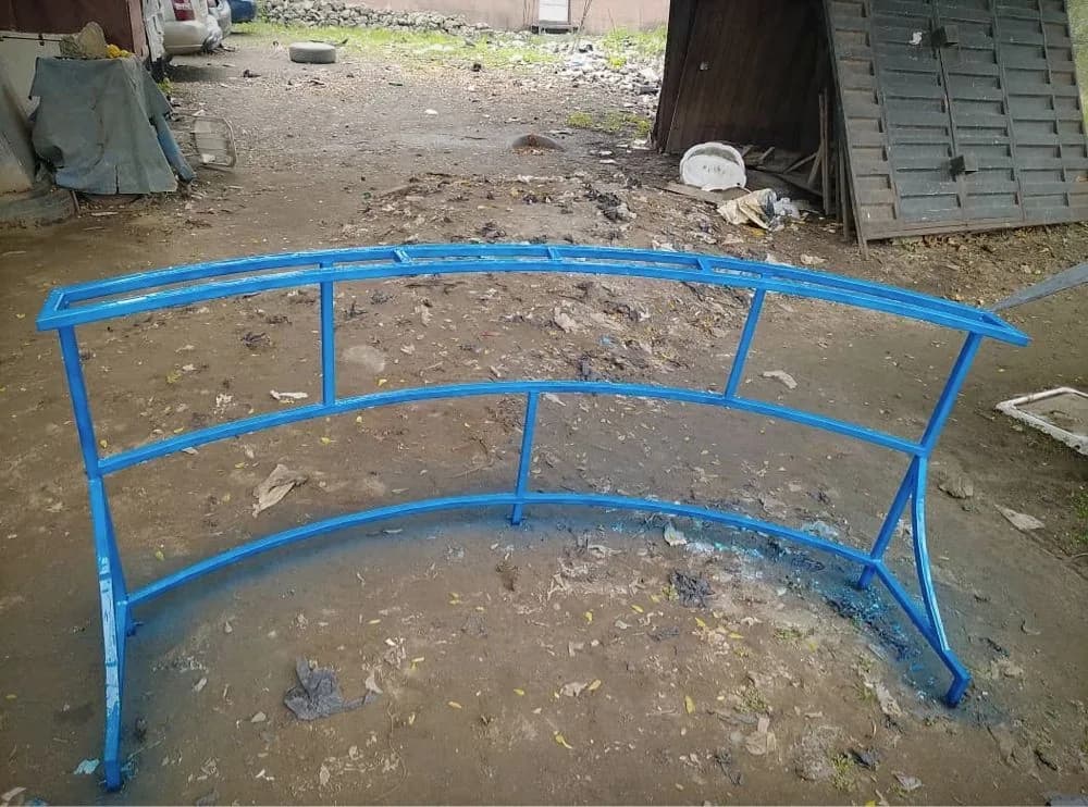 Curved steel frame, welded and painted blue, at the Loyal Point workshop